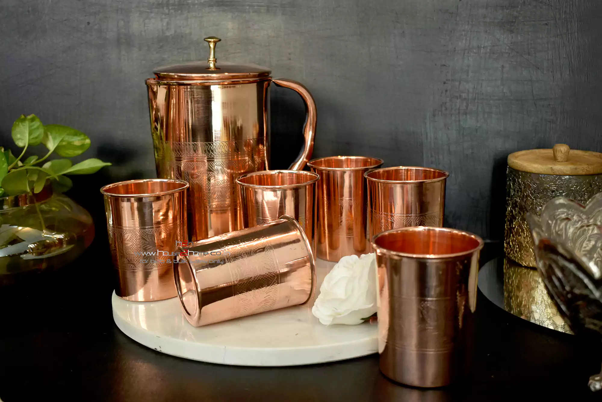 A handcrafted copper jug and tumbler set, featuring intricate engraving and a high-shine finish.