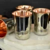 A set of elegant stainless steel tumblers with a warm copper interior finish and polished metal exterior.