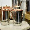A set of elegant stainless steel tumblers with a warm copper interior finish and polished metal exterior.