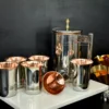 A sleek stainless steel and copper pitcher and tumbler set, displaying premium metallic craft and finish.