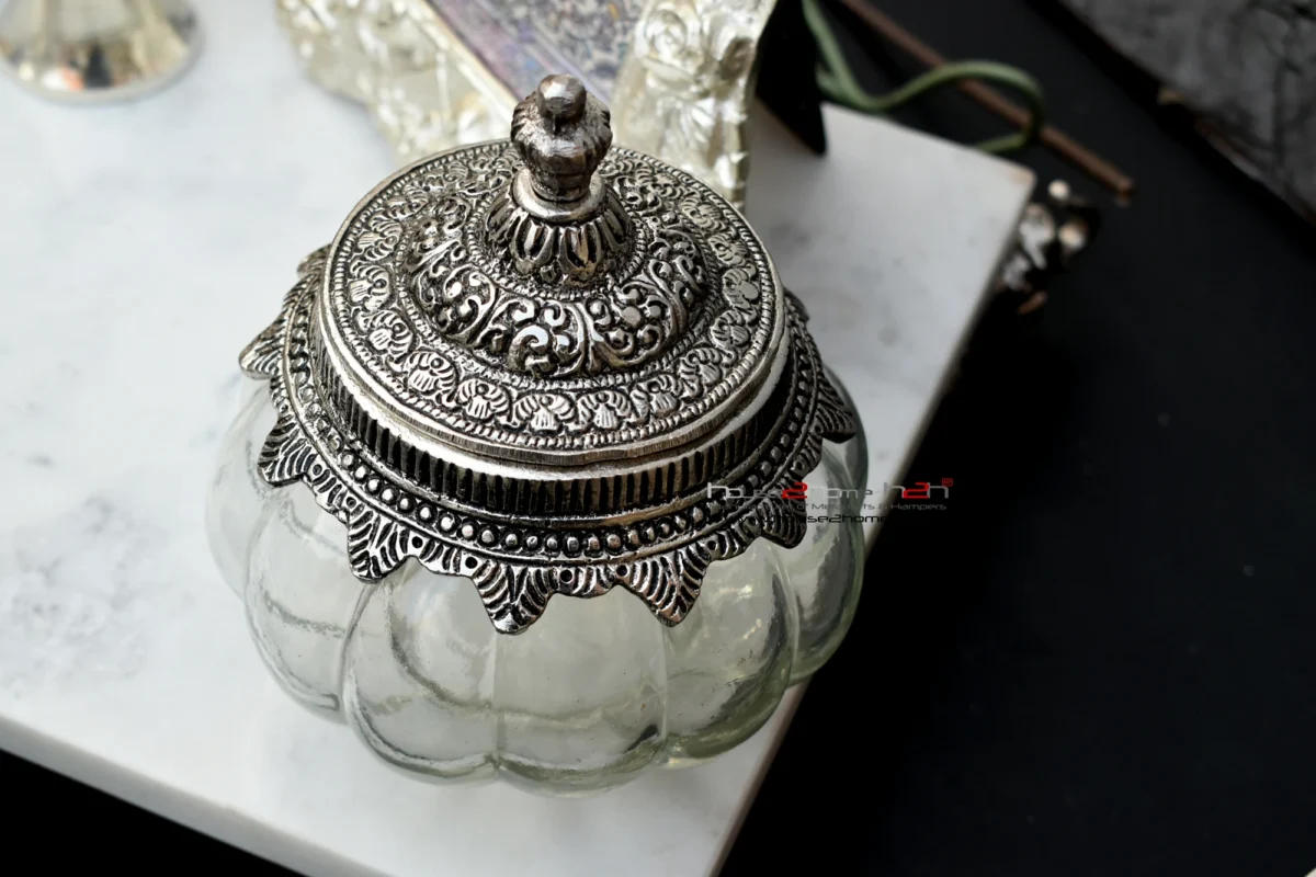 : Elegant glass jar featuring an intricate, antique-finish silver metal lid, perfect for premium table decor.