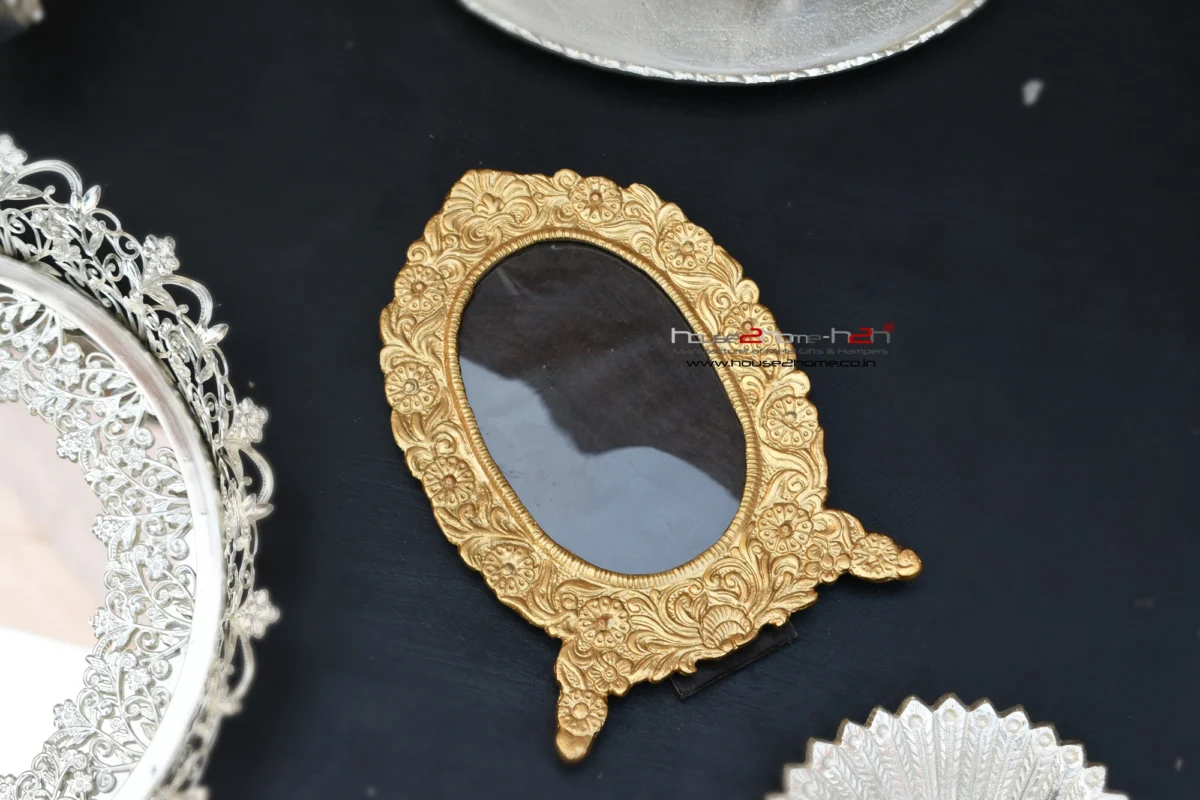 Oval metal photo frame in a rich gold finish with intricate floral embossing for a classic decorative aesthetic.