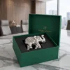An elegant silver-tone metal elephant statue featuring detailed traditional body carvings and luster.