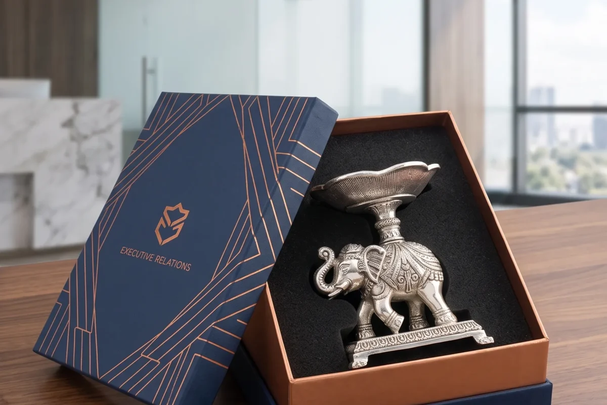 A detailed silver-toned metal elephant platter figurine carrying a scalloped bowl, presented inside a gift box.