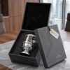 A modern silver metal and glass decorative diya presented inside a custom-fitted executive gift box.