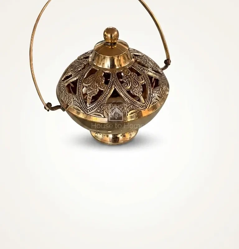 A handcrafted brass pot featuring intricate openwork patterns and a curved metal handle for a premium look.