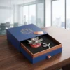 A silver metal lotus diya and tealight holder resting on a red and white base inside a luxury gift box.