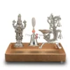 This German silver pooja set features a detailed deity idol, a prayer bell, and an ornate peacock diya stand.
