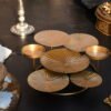 A decorative candle display stand with a polished gold metallic coating designed by House2Home.