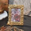 A decorative picture holder with a textured metallic gold coating designed by House2Home for tabletop display.
