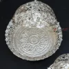 silver finish decorative metal bowl with intricate cutout styling, beautifully displayed as a luxury accent.