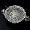 An exquisite metal bowl with handles and a dome lid featuring a brilliant silver finish.