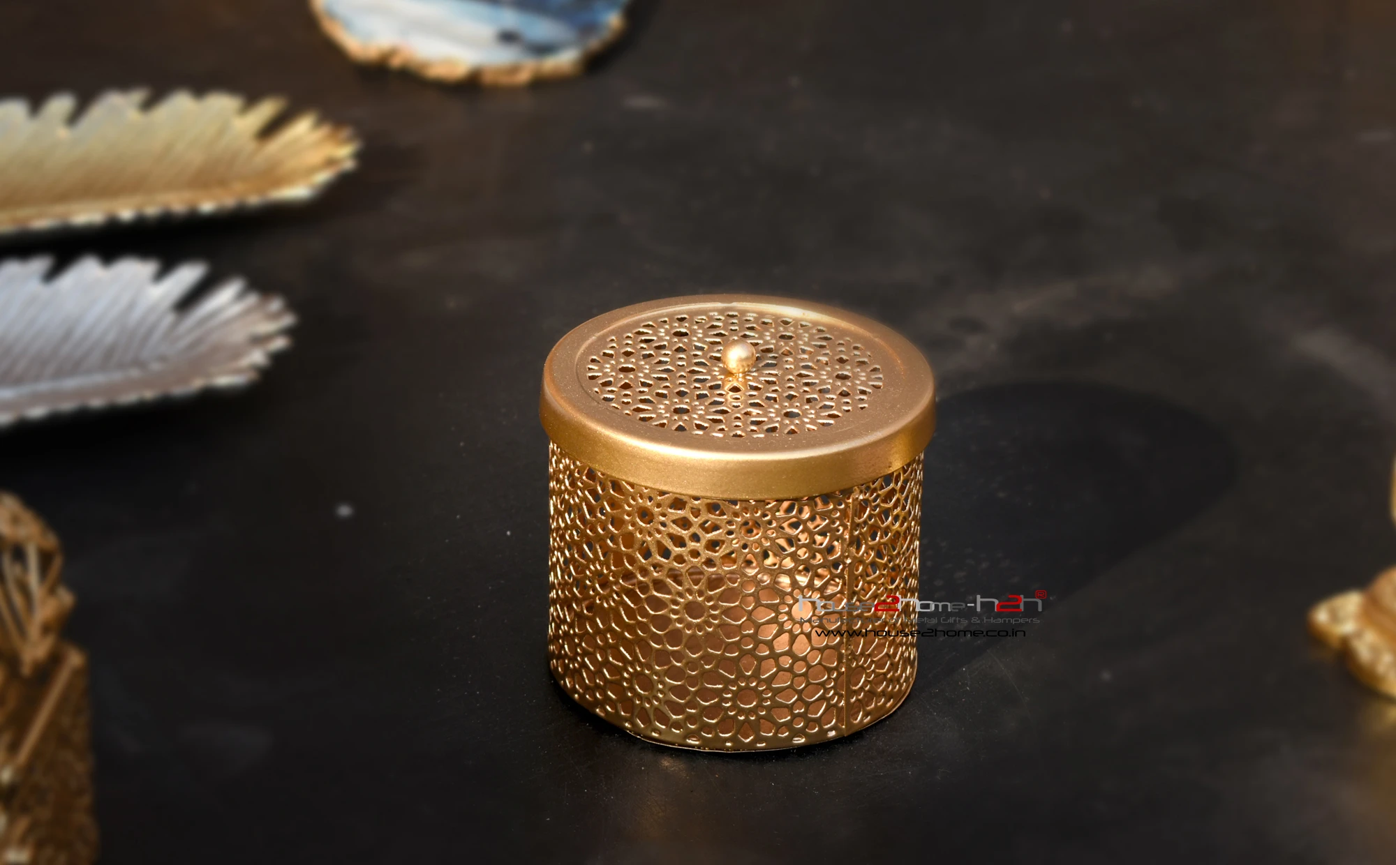 A stylish gold colored metal utility container with intricate Jali cutwork patterns by House2Home.