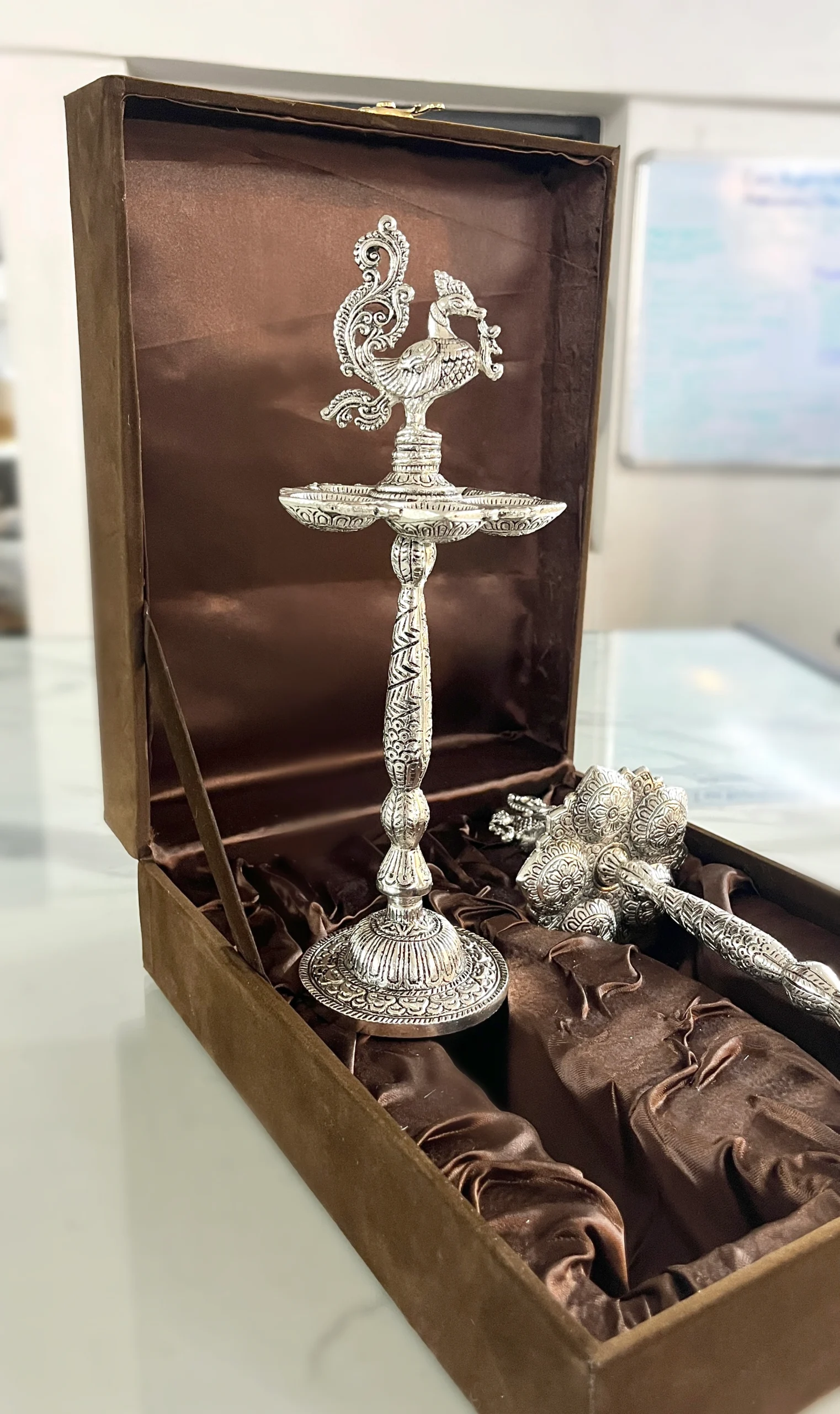 Ornate German silver peacock diya packed in a presentation box, ideal for luxury wedding return gifts.