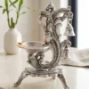 German silver peacock diya with hanging bells displayed as an elegant decorative oil lamp for festive home décor.