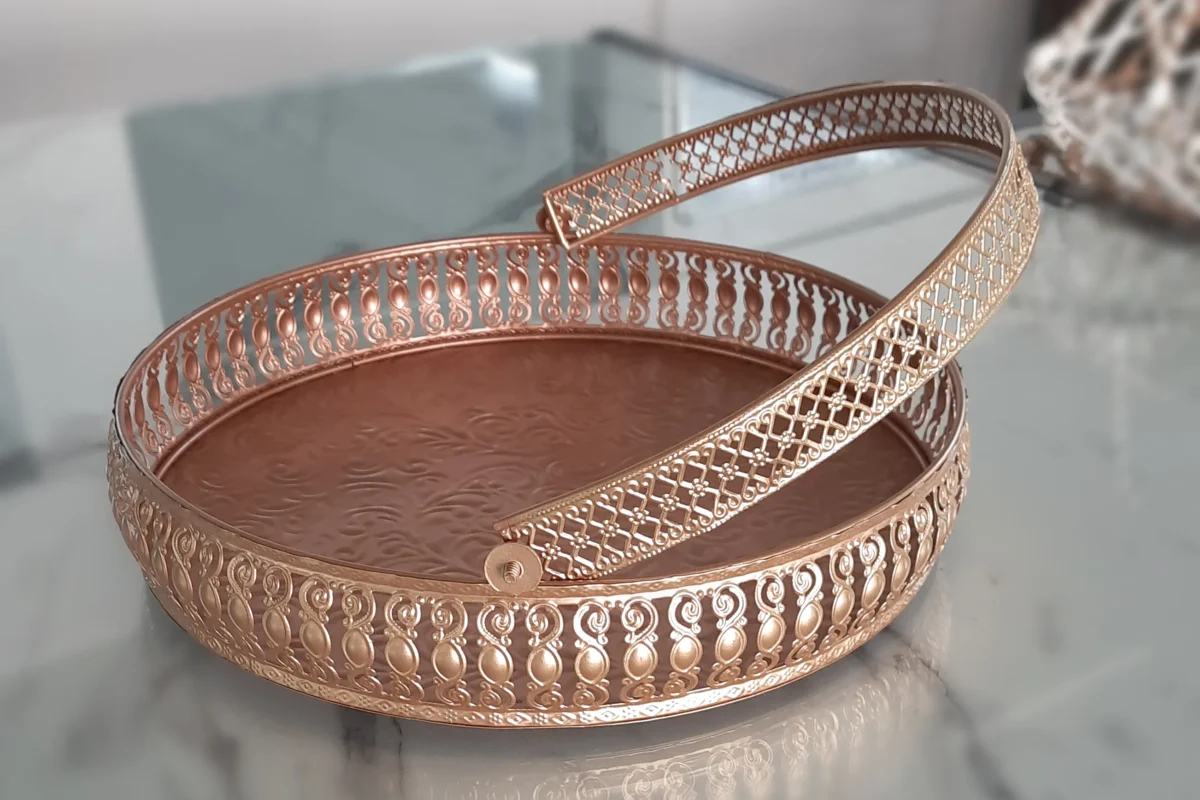 Round brass decorative basket with a matching handle, featuring intricate cutwork metal craftsmanship.