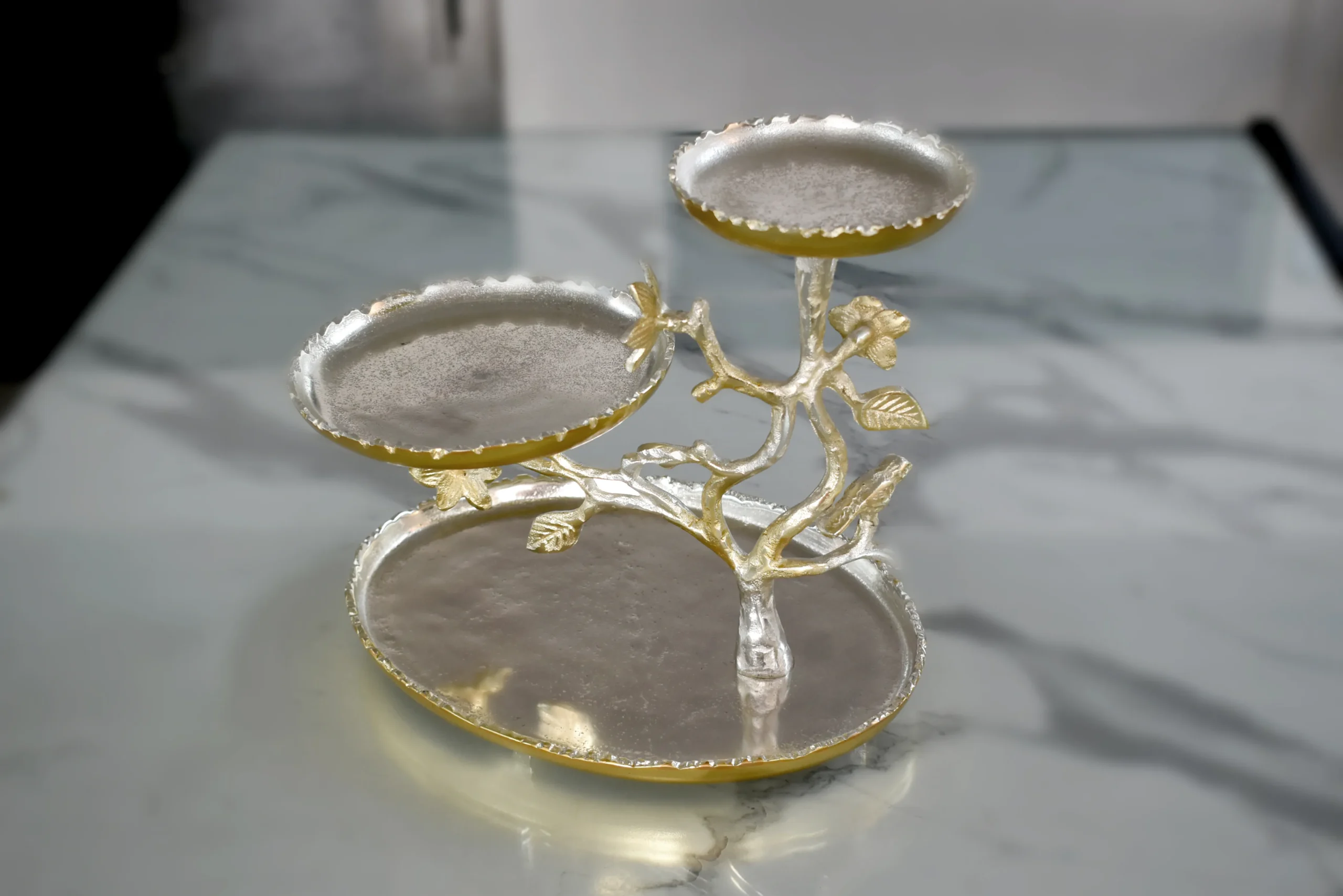 Silver and gold two-tone metal tree platter with three tiered trays and sculpted floral branches.