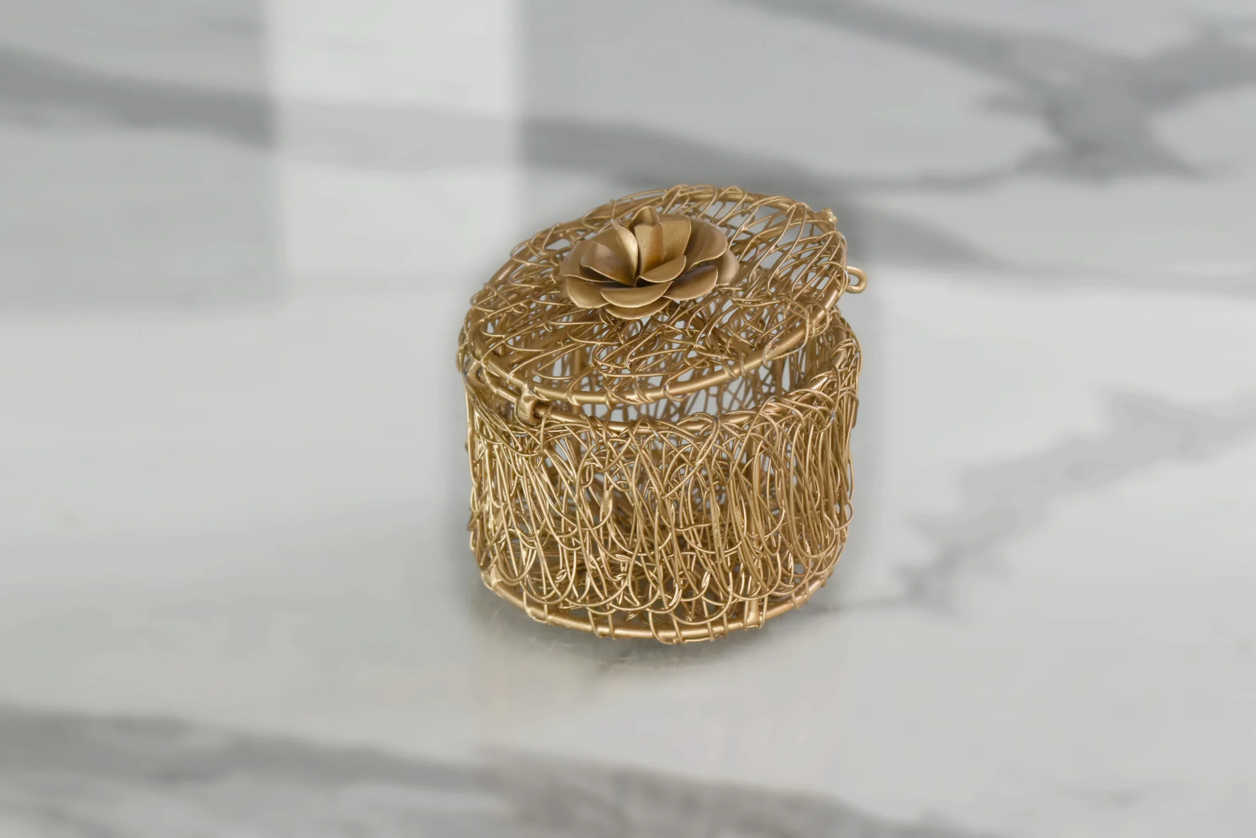 Intricate gold wire trinket container presented as a luxury shaadi return gift box for wedding guests.