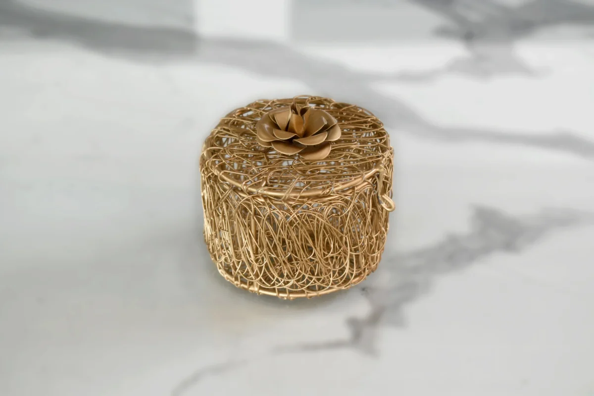 Intricate gold wire trinket container presented as a luxury shaadi return gift box for wedding guests.