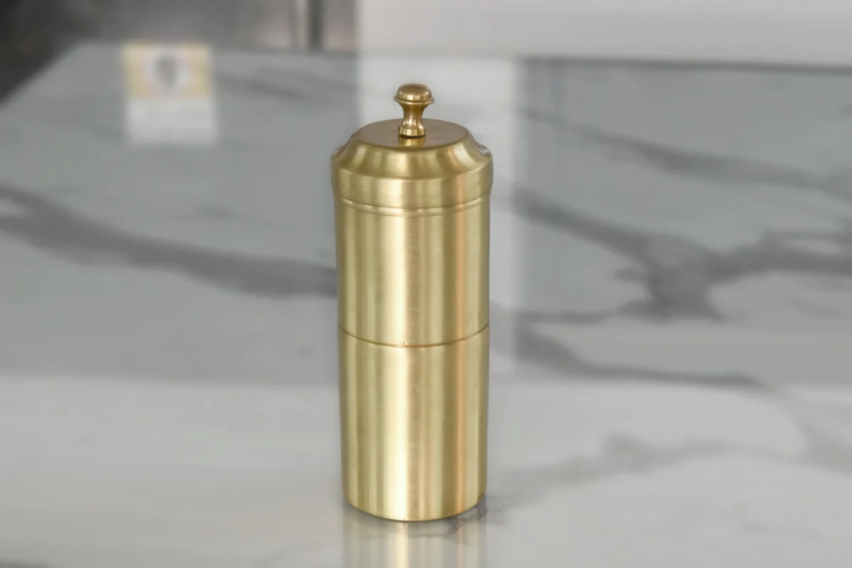 Golden brass South Indian coffee filter set styled as a luxury wedding return gift for traditional shaadi guests.
