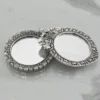 Silver-plated embossed metal pocket mirrors with ornate frames for traditional dressing and vanity decor.