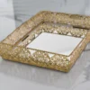 Gold-finished filigree metal tray with mirrored base for elegant home decor and gifting displays.
