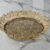 Ornate round gold metal mirror tray styled for luxury wedding return gifts and shaadi trousseau displays.