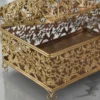 Gold-finished open metal filigree storage box with domed hinged lid and floral lattice design.