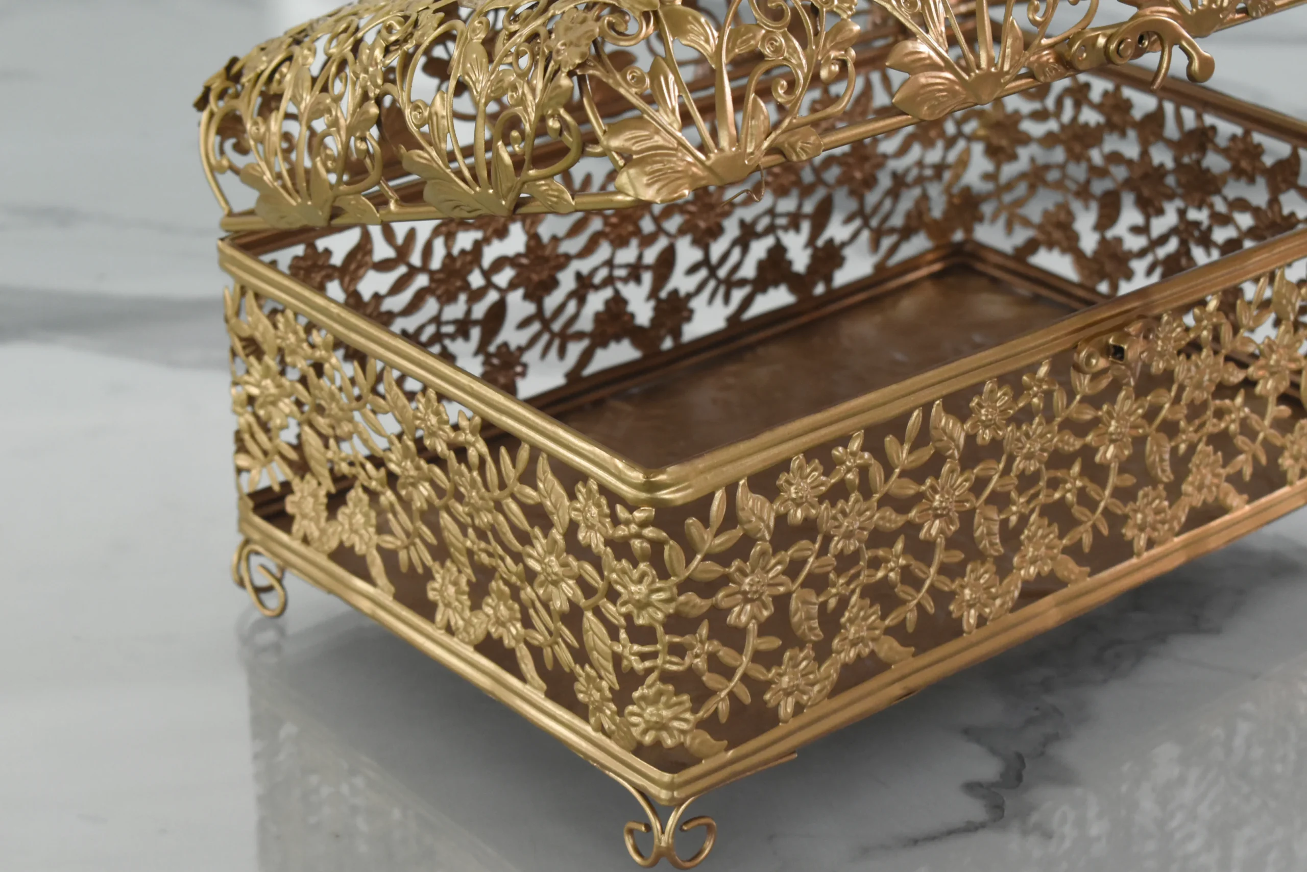 Gold-finished open metal filigree storage box with domed hinged lid and floral lattice design.