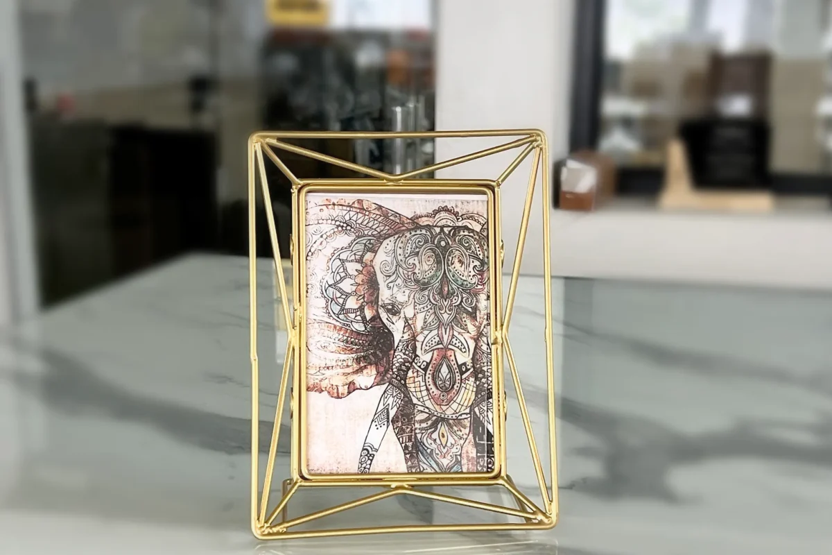 Modern geometric wire photo frame crafted from durable iron with a polished gold finish and art print insert.