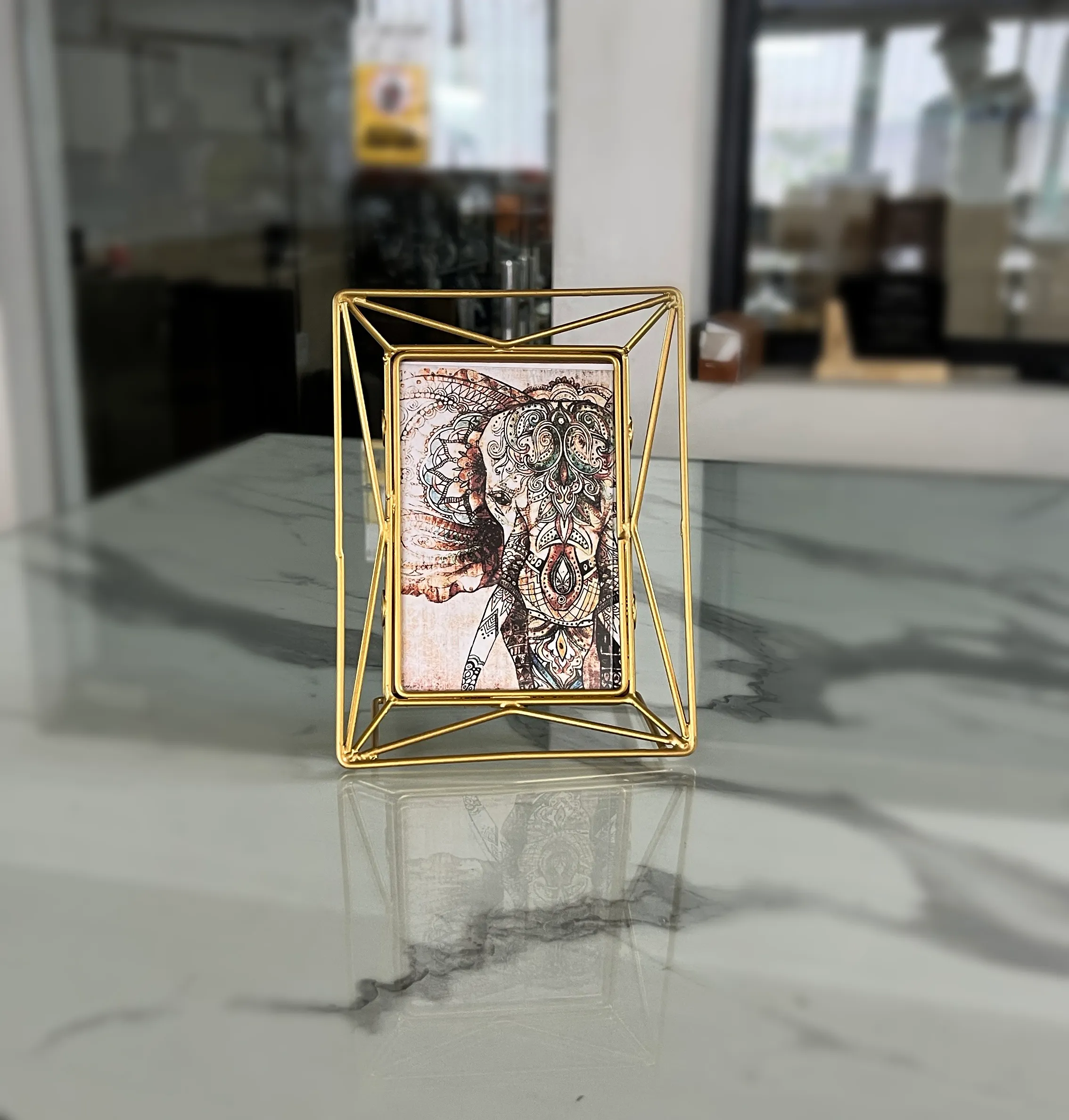 Modern geometric wire photo frame crafted from durable iron with a polished gold finish and art print insert.