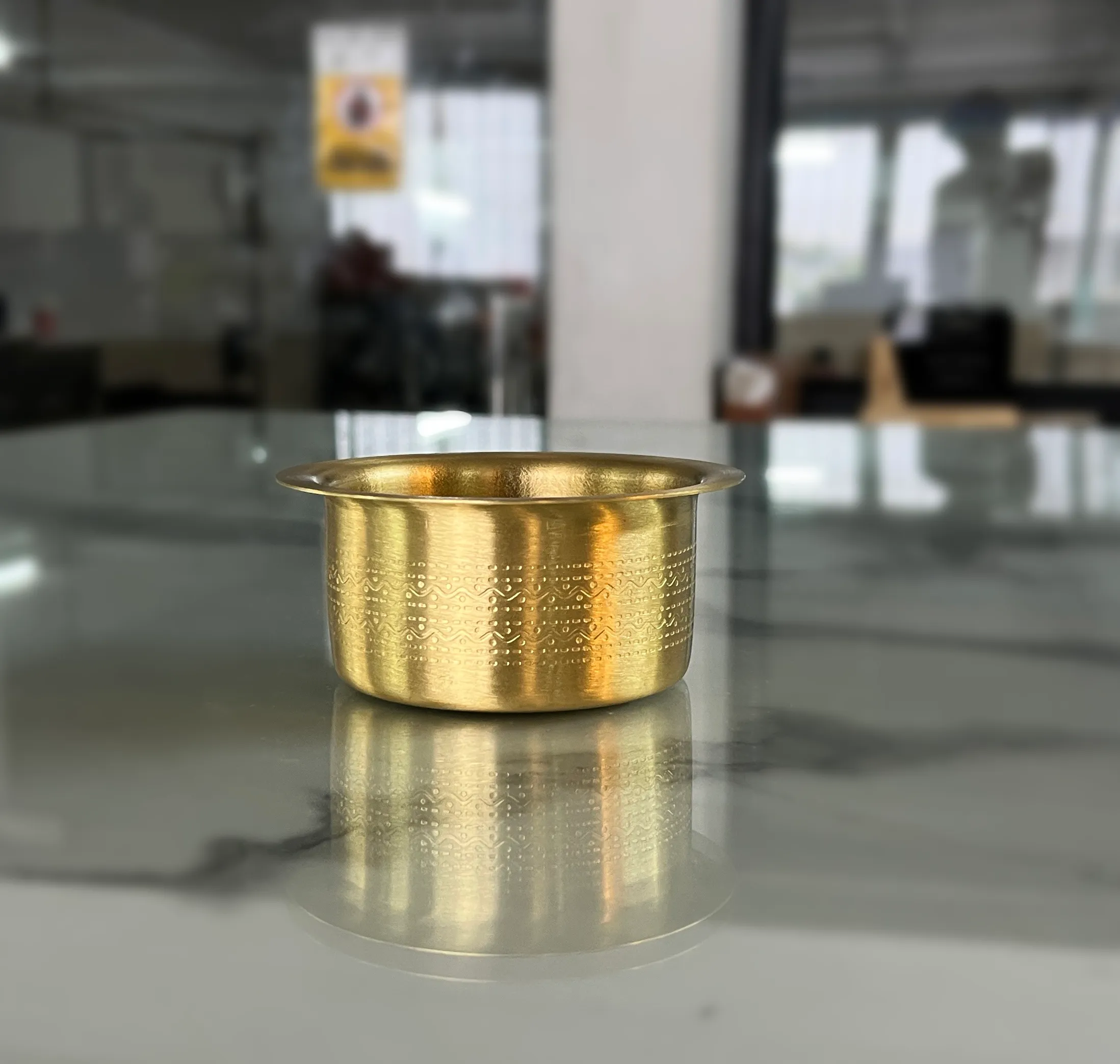 Elegant brass coffee dabarah and tumbler styled inside a wedding return gift hamper for a traditional shaadi.